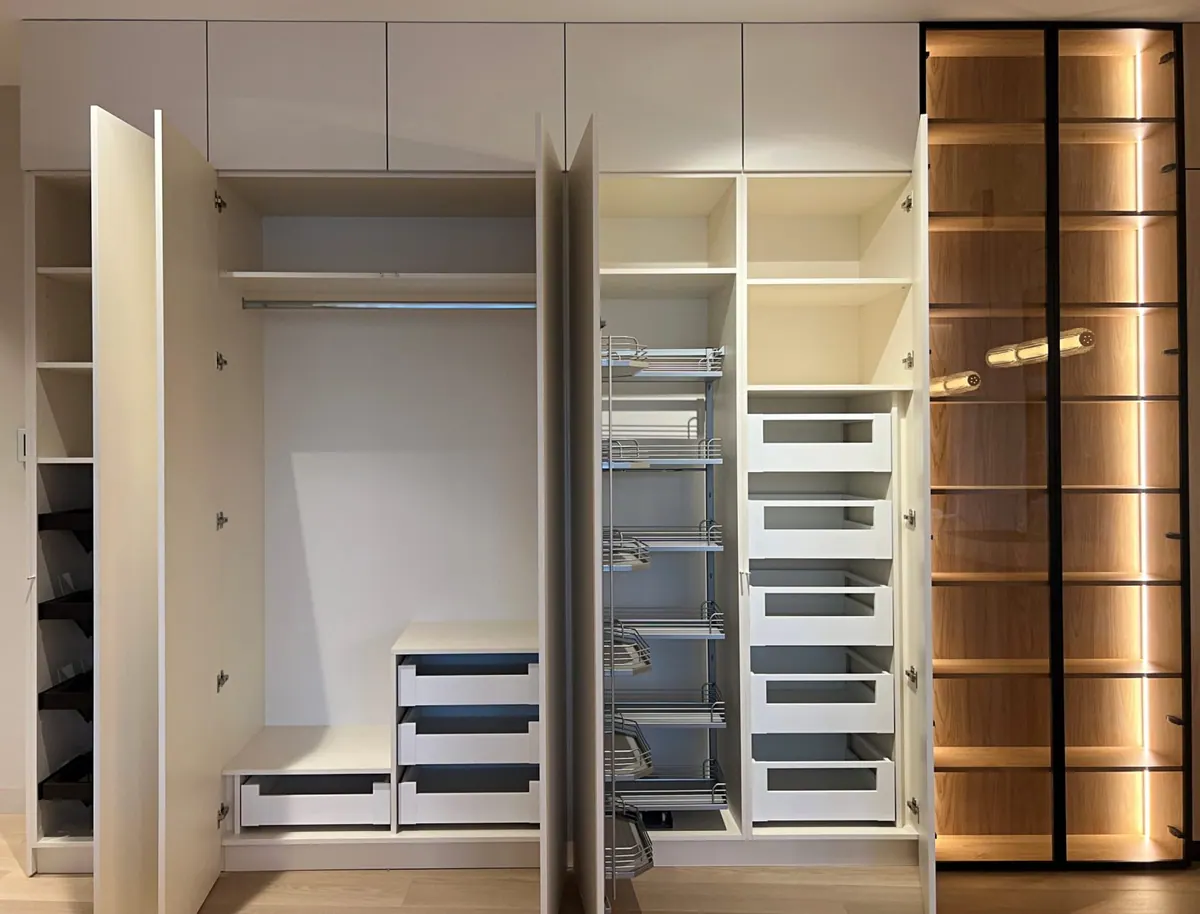 Offener Kücheneinbau mit Apothekerauszügen, Schubladen und beleuchteten Glasvitrinen